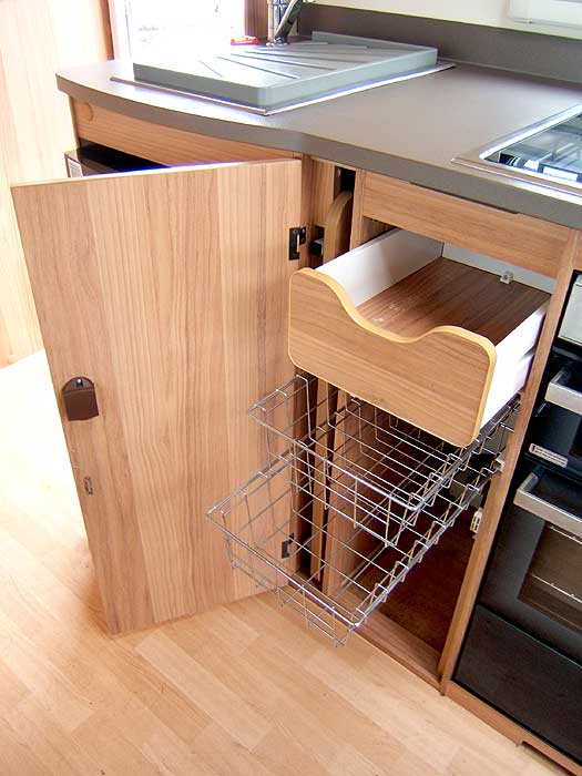 The cupboard below the woktop with storage baskets and cutlery drawer.